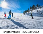 Group of people skiing and snowboarding down the ski slope or piste in Pyrenees Mountains. Winter ski holidays in El Tarter, Grandvalira, Andorra