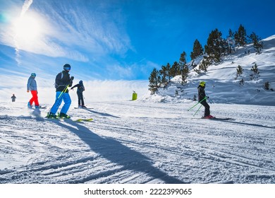 Group of people skiing and snowboarding down the ski slope or piste in Pyrenees Mountains. Winter ski holidays in El Tarter, Grandvalira, Andorra - Powered by Shutterstock
