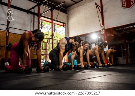 Group of people smiling while doing crossfit exercise