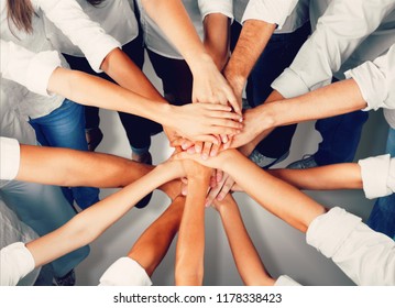 Group of people stacking hands together - Shutterstock ID 1178338423