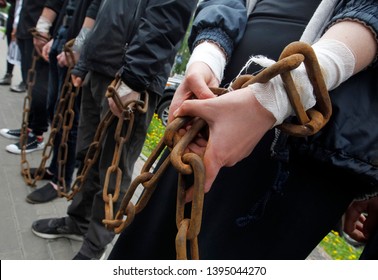 group of people stand with chained hands close-up