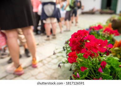 Group Of People Standing In Line In A Hot Summer, Waiting For The Arrival Of The Train, The Bus, The Cable Car.