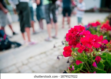 Group Of People Standing In Line In A Hot Summer, Waiting For The Arrival Of The Train, The Bus, The Cable Car.