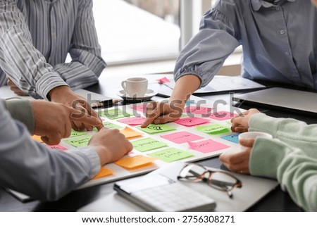 Group of people with sticky notes working on business plan in office