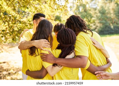 Group Of People At Team Building Exercise Put Heads Together And Hug In Nature