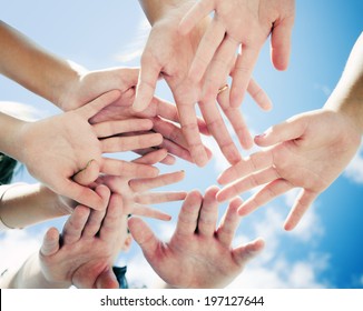 A group of people with their hands all in the middle.
