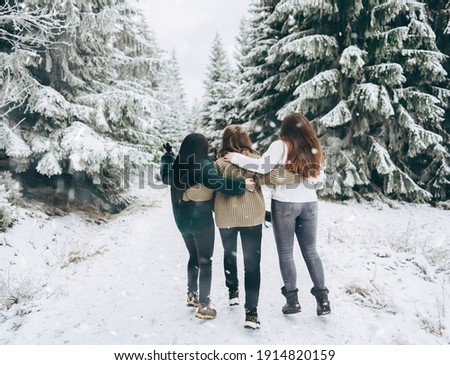 A group of people from three friends jump merrily against the background of a snowy winter landscape.Winter lifestyle.enjoy the little things
