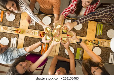 Group of people toasting and looking happy at a restaurant - Powered by Shutterstock