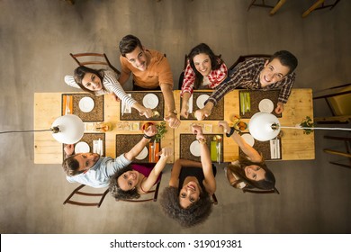 Group of people toasting and looking happy at a restaurant