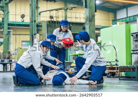 A group of people using an AED to help a worker who collapsed at a factory