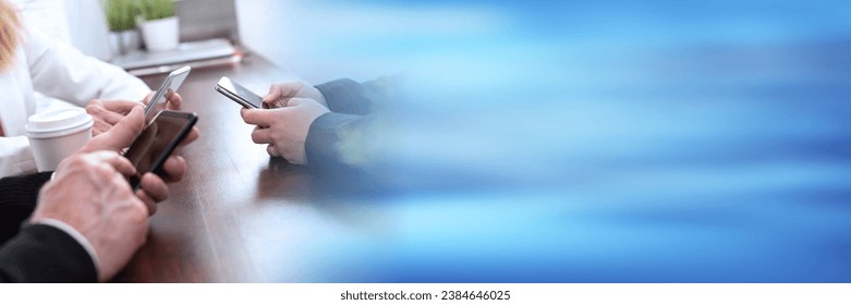 Group of people using and looking at mobile phone together; panoramic banner