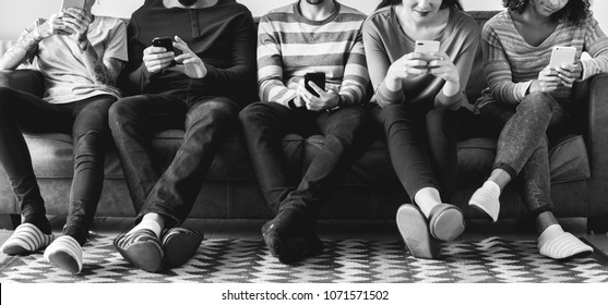 Group Of People Using Mobile Phone On Couch