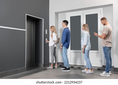 Group of people waiting in line for elevator while woman pressing call button - Shutterstock ID 2212934237