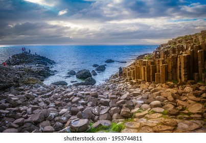 A Group Of People Walk On The Stone Foundations Of The Giant's Causeway