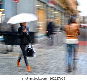 Group Of  People Walking Down The Street In Motion Blur