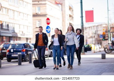 Group Of People Walking On A Street With Confidence. Businessmen And Businesswomen Traveling Together.