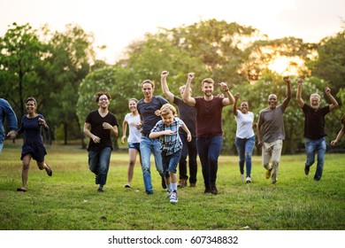 Group Of People Walking And Running Playful In The Park