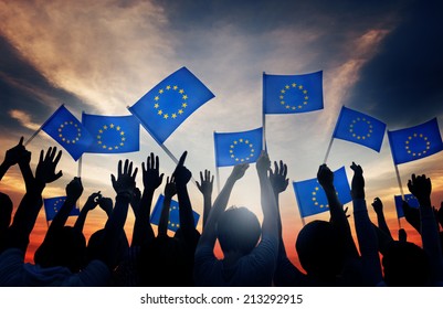 Group Of People Waving European Union Flags In Back Lit