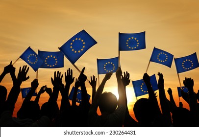 Group Of People Waving European Union Flags In Back Lit