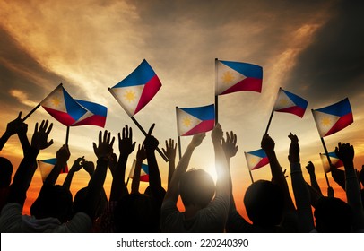 Group of People Waving Filipino Flags in Back Lit