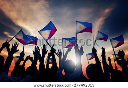 Group of People Waving Filipino Flags in Back Lit