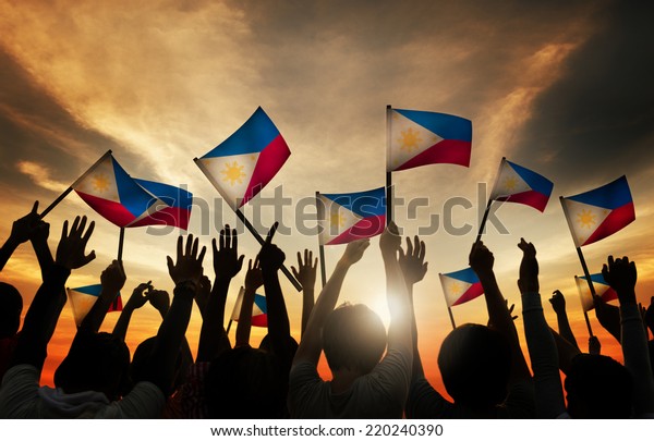 Group of\
People Waving Filipino Flags in Back\
Lit