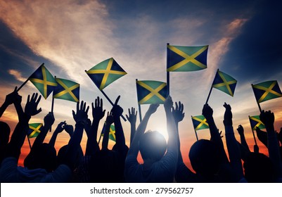 Group Of People Waving Flag Of Jamaica In Back Lit Concept