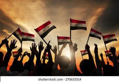 Group Of People Waving Flag Of Syria In Back Lit