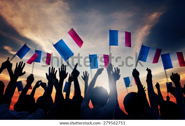 Group\
of People Waving French Flags in Back Lit\
Concept