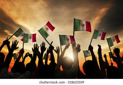 Group Of People Waving Mexican Flags In Back Lit