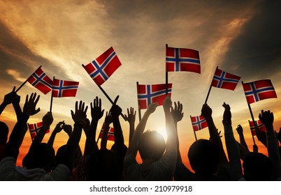 Group Of People Waving Norwegian Flags In Back Lit