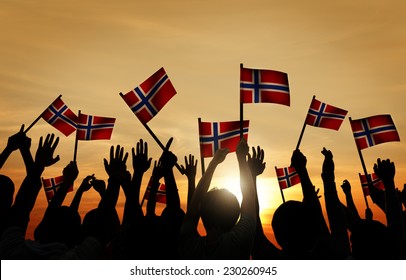 Group Of People Waving Norwegian Flags In Back Lit