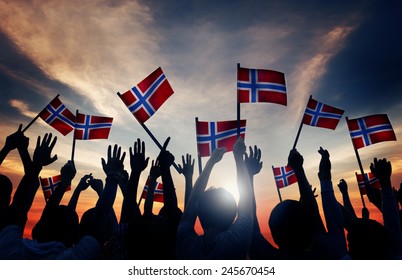 Group Of People Waving Norwegian Flags In Back Lit