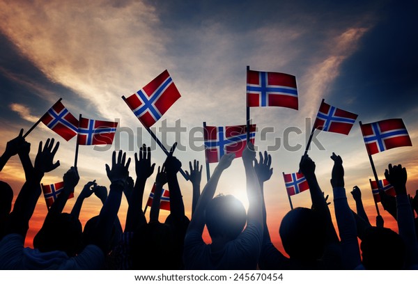 Group of
People Waving Norwegian Flags in Back
Lit