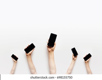 Group Of People's Hands Holding Phones And Rising Them Up 