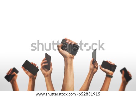 group of people's hands holding phones and rising them up against a white backgroud