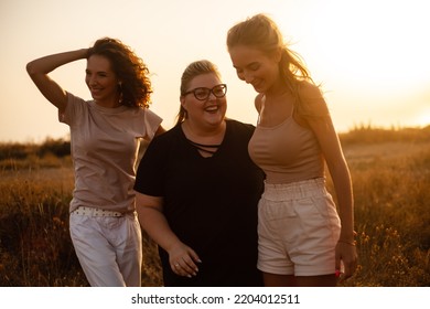 Group Pf Three Friends, Plus Size With Two Thin Girls Spend Happy Time Together In The Nature. Beautiful Overweight And Strong Women Have Fun, Enjoy The Moment Of Sunset .