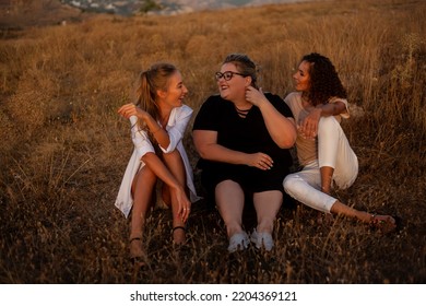 Group Pf Three Friends, Plus Sizewith Two Thin Girls Spend Happy Time Together In The Nature. Beautiful Overweight And Strong Women Have Fun, Enjoy The Momet Of Sunset .