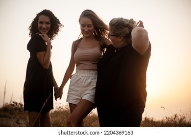 Group Pf Three Friends, Plus Size With Two Thin Girls Spend Happy Time Together In The Nature. Beautiful Overweight And Strong Women Have Fun, Enjoy The Momet Of Sunset .