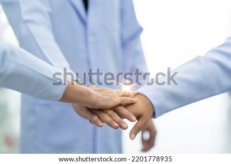 group of pharmacists join hands and work together as a professional team working together in a pharmacy.