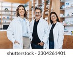 Group of pharmacists standing together and looking at the camera in a chemist. Three healthcare providers working in a pharmacy.