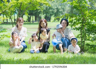 Group Photo Of Asian Families Playing In A Green Park