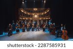 Group Photo: Portrait of Symphony Orchestra Performers on the Stage of a Classic Theatre, Looking at the Camera Together and Smiling. Successful and Professional Musicians Posing