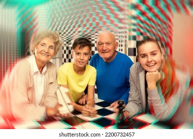 Group Photo Of Positive Grandparents And Grandkids Standing At Big Chess-board In Escape Room.