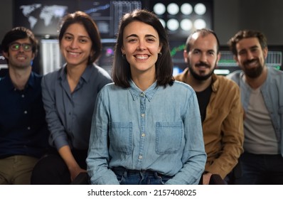 Group Photo Of Stock Traders Teams In The Office Looking At Camera. Focus On Woman In The Middle.