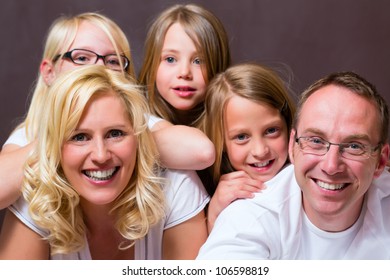 Group Picture Of A Young Family, Father, Mother And Three Children In Bedroom