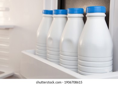 Groupe de carafes de lait en plastique entreposées et alignées dans la porte du réfrigérateur. Le calcium est bon pour la santé