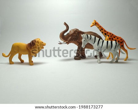 Group of plastic toy animals, Lion, elephant, zebra and giraffe with a fight style - Miniature Plastic Toy Animals on white background