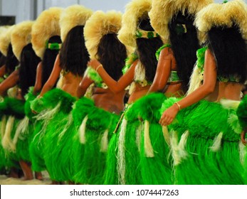Group of Polynesian dancers in traditional green dresses performing in Raiatea, French Polynesia
