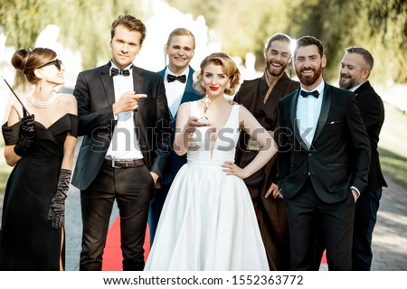 Group portrait of a famous movie actors standing together on the red carpet during awards ceremony outdoors